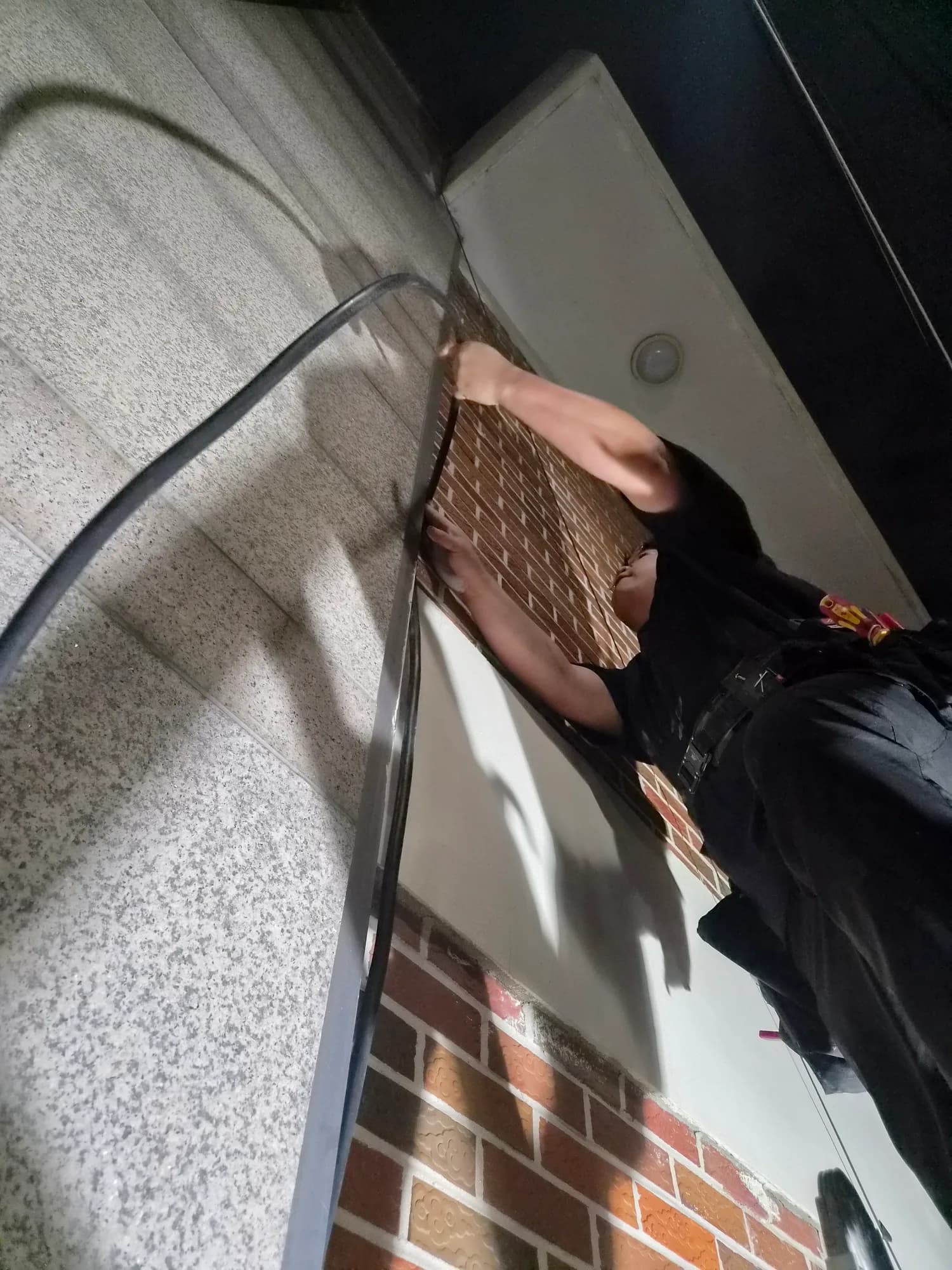 양가네옛날뒷고기 외벽 모서리 배선 경로를 확인하는 작업자